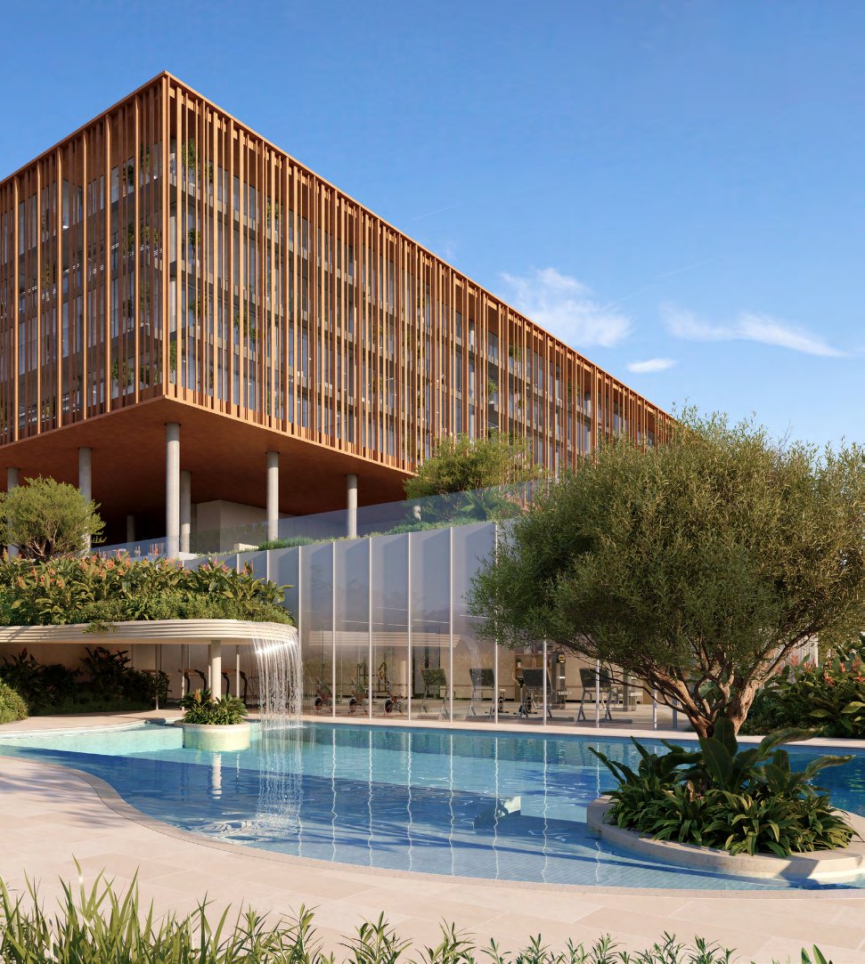 Swimming pool with waterfall beside the glass-fronted gym and louvred offices
