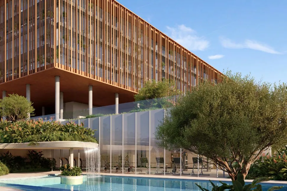 Swimming pool with waterfall beside the glass-fronted gym and louvred offices